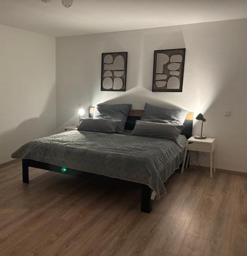 a bedroom with a bed with two pictures on the wall at Ferienwohnung Am Sonnenrain in Albshausen