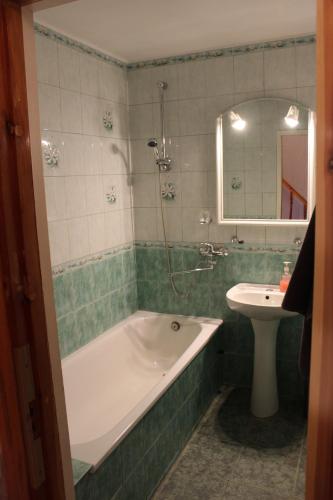 a bathroom with a bath tub and a sink at Brīvdienu māja Atvari in Jūrkalne