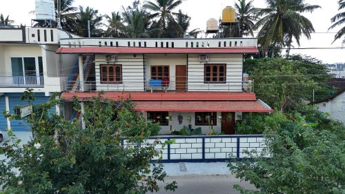 ein weißes Haus mit einem roten Dach in der Unterkunft Coorg peacock feathers home stay in Kushālnagar