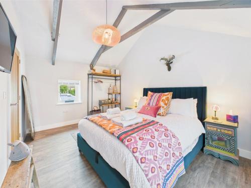a bedroom with a bed and a cross on the wall at Cosy Cornish Cottage with Firepit & Parking in Newlyn East