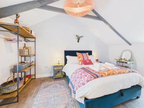 een slaapkamer met een bed en een boekenplank bij Cosy Cornish Cottage with Firepit & Parking in Newlyn East