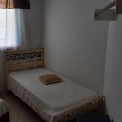 un piccolo letto in una piccola stanza con finestra di Apartamento Beira-mar a Guarapari