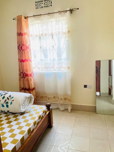 a bedroom with a bed and a window at KidotuiVillaHome in Arusha