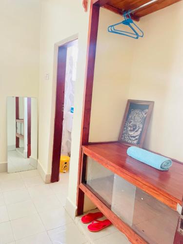 a room with a wooden shelf with red slippers at KidotuiVillaHome in Arusha