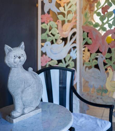 a cat statue sitting on a table next to a chair at Hotel Le Focette in Marina di Pietrasanta