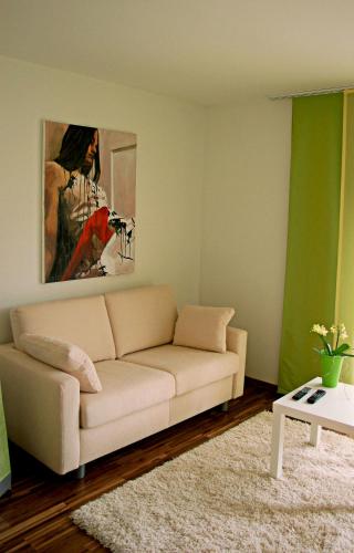 a living room with a white couch and a painting at Hotel F-RITZ in Schleswig
