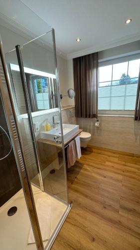 a bathroom with a glass shower and a sink at Landhaus Bergkrone in Willingen