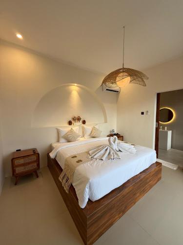 a bedroom with a large bed with a large white bedspread at Pinggan Everest Bali in Gretek