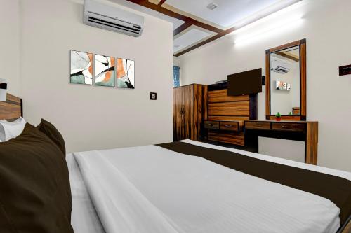 ein Schlafzimmer mit einem Bett und einem Schreibtisch mit Spiegel in der Unterkunft Hotel O Galaxy Inn in Ballygunge