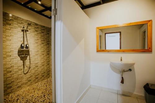 een badkamer met een wastafel en een spiegel bij Nuansa Penida Hostel in Nusa Penida