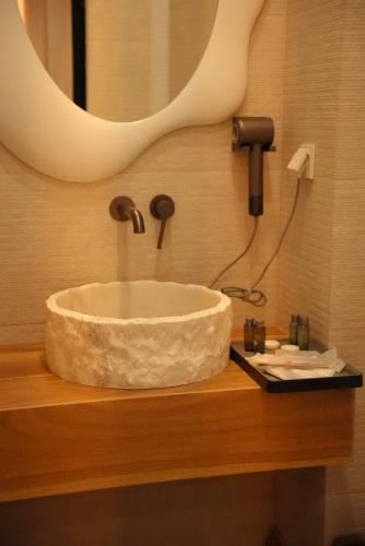 ein Waschbecken im Bad mit Spiegel in der Unterkunft Dastan Grand Hotel in Jalal-Abad