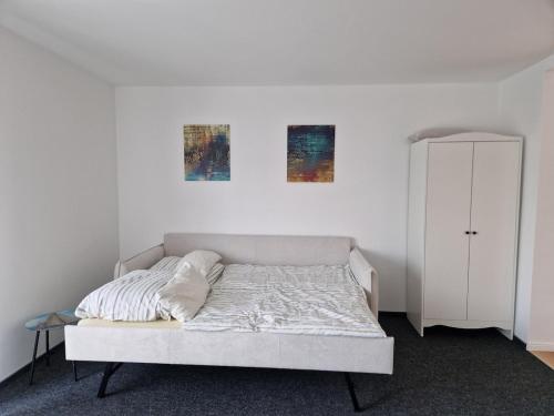 a bed in a bedroom with two pictures on the wall at Modernes Apartment in Huttenberg