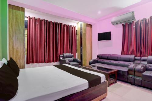een slaapkamer met een bed, een bank en een televisie bij Hotel O shreyansh in Chupra