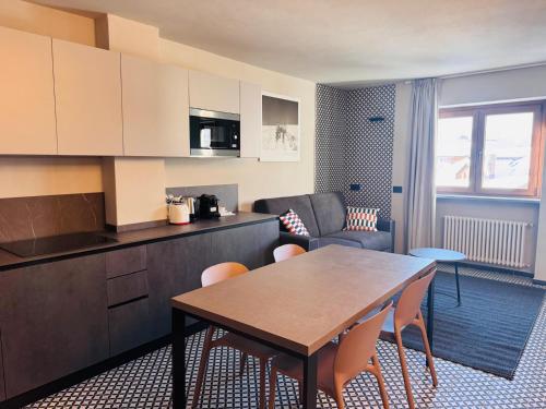 een keuken en een woonkamer met een tafel en stoelen bij Central Guest in Sauze dʼOulx