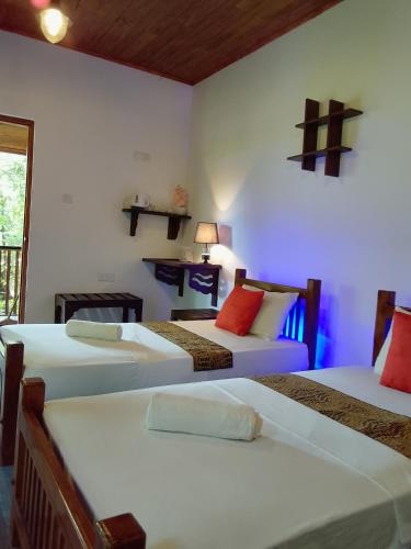 a room with three beds in a room at Peek & Pick Garden resort in Habarana