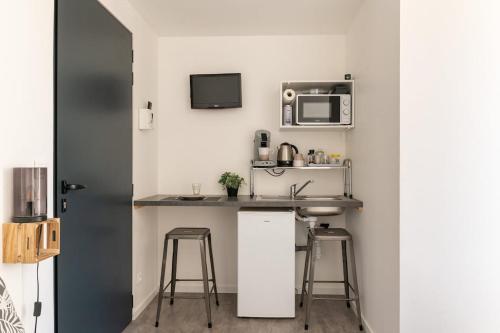 een kleine keuken met een spoelbak en een magnetron bij Studio Chambre St Genest Malifaux in Saint-Genest-Malifaux