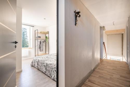 een slaapkamer met een bed en een hal bij Studio Chambre St Genest Malifaux in Saint-Genest-Malifaux