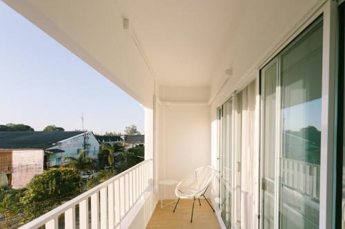 a white chair sitting on the balcony of a house at PANI Place Khaolak in Khao Lak