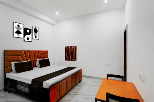 a bedroom with a bed and a table at Hotel O by OYO Radha Raman Guest House in Rait