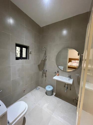 a bathroom with a toilet and a sink and a mirror at Forever Appartements Cosy luxe in Cotonou
