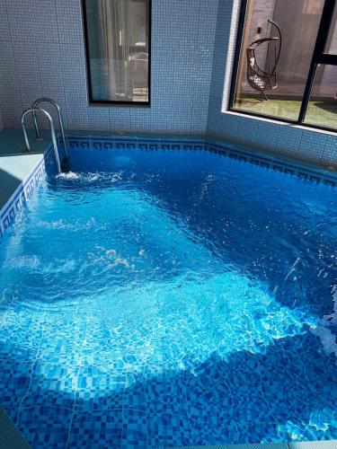 a large pool with blue water in a room at شاليهات ايفا 2 in Taif
