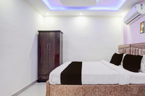 ein Schlafzimmer mit einem Bett und einem Holzschrank in der Unterkunft Hotel O Royal Sangrila Inn in Dānāpur