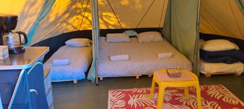 a room with two beds in a tent at Tente aménagée 4pp in Camurac