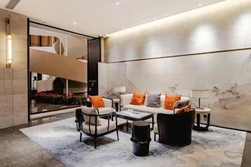 a lobby with a couch and two chairs and a table at Dajiuhua Hotel in Chizhou