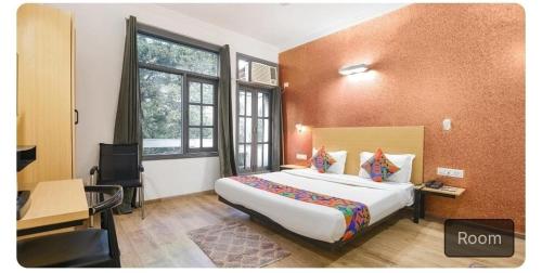 een hotelkamer met een groot bed en een bureau bij Hotel dev inn in Gurgaon
