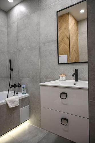 a bathroom with a sink and a mirror and a tub at Cozy Studio Heart in Banská Bystrica