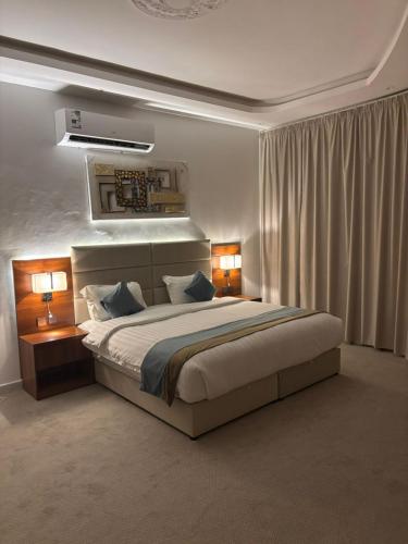a bedroom with a large bed with two lamps at فندف رياح الجزيرة في السليل in Ahl Ḩunaysh