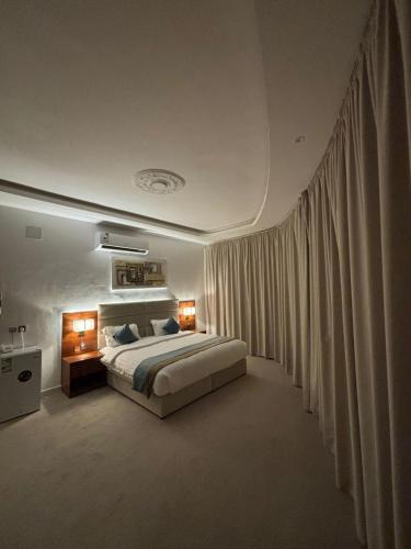 a bedroom with a large bed and curtains at فندف رياح الجزيرة في السليل in Ahl Ḩunaysh