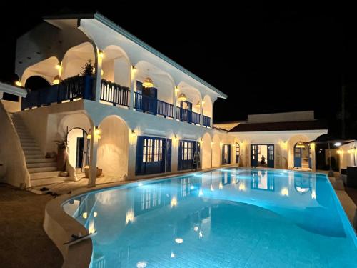 a large swimming pool in front of a house at night at Casa Bella Khaolak in Khao Lak