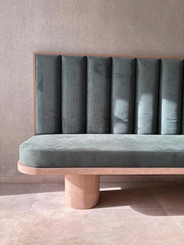 eine Bank in einem Raum mit einer Wand in der Unterkunft Hôtel Casa C in Propriano