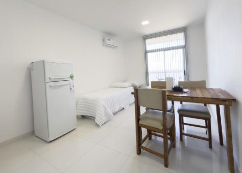 eine Küche mit einem Tisch, einem Kühlschrank und einem Bett in der Unterkunft Moderno con vistas al Río in Pueblo Esther