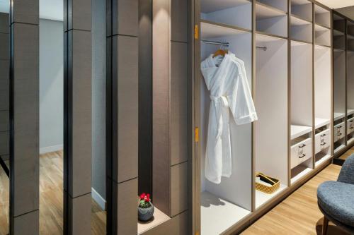 a dressing room with a robe hanging on a door at Sheraton Jeddah Hotel in Jeddah