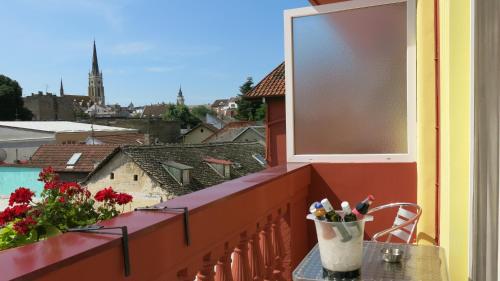 a balcony with a table with a cup of pens at Hotel Fontana in Novi Sad