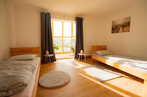 een slaapkamer met twee bedden en een raam bij FEWO 2 zur schönen Aussicht in Hinterschmiding
