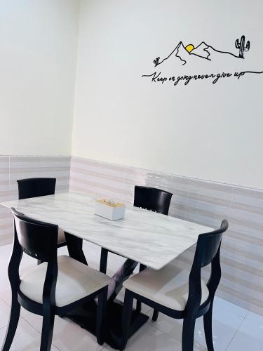 een eettafel met stoelen en een witte tafel bij Farwa home in Kampong Rusamileh