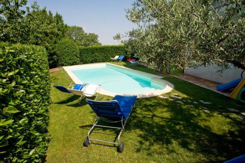a yard with two chairs and a swimming pool at Albergo Ristorante Il Terziere in Trevi