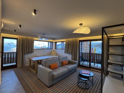 ein Wohnzimmer mit Sofa und Tisch in der Unterkunft PopAlp la Plagne - Hôtel et Restaurant in La Plagne Tarentaise