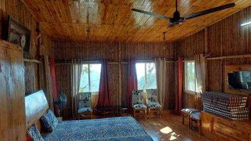 ein Schlafzimmer mit Bett und Deckenventilator in der Unterkunft Kutuumb Morni Hills in Morni