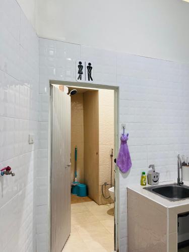 a bathroom with a sink and a toilet in a room at Farwa home in Kampong Rusamileh