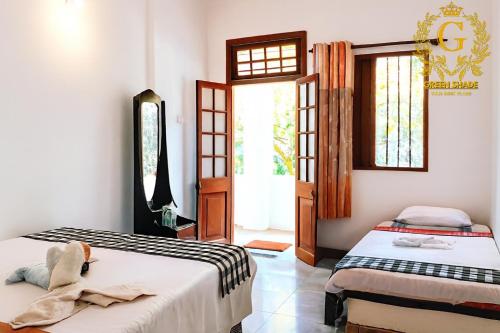 een slaapkamer met twee bedden en een raam bij Green Shade Resort & Haritha Sewana Hotel in Nallathanniya