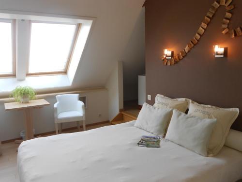 a bedroom with a white bed with a window at Kraaiberg in Ploegsteert