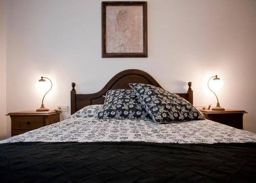 a bedroom with a bed with two lamps on two tables at Casa Rural El Secreto de las Eras in Candelario
