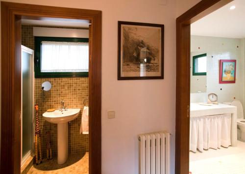 a bathroom with a sink and a bath tub at Casa Rural El Secreto de las Eras in Candelario