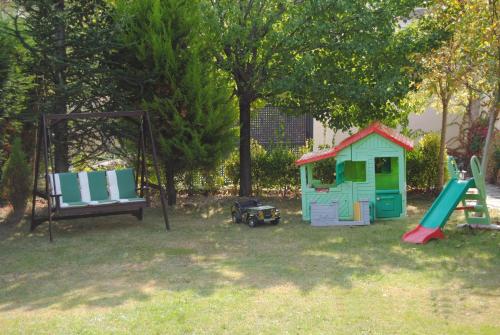 a playground with a swing and a play house at Casa Rural El Secreto de las Eras in Candelario