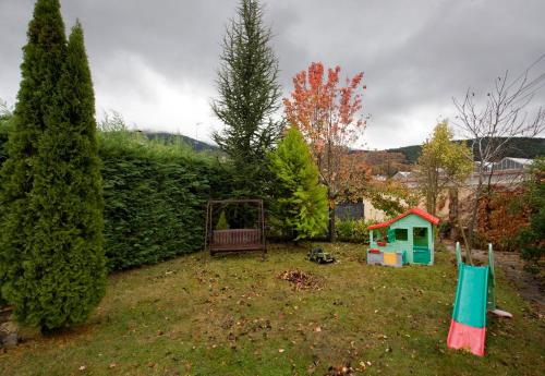 a yard with a playground and a fence and trees at Casa Rural El Secreto de las Eras in Candelario