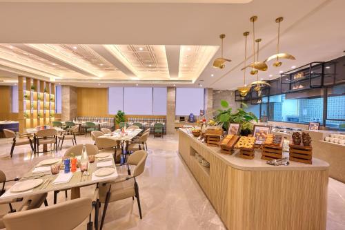 een restaurant met tafels en stoelen en een bar bij Riviera Sarovar Portico Pathankot in Pathankot